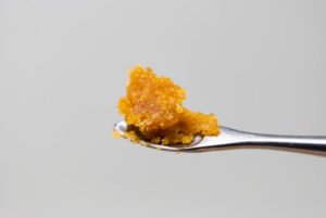 Échantillon de wax THC cireuse et ambrée sur papier sulfurisé
